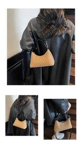 Detail of punk style pearl hobo bag with black leather strap on a model with coat