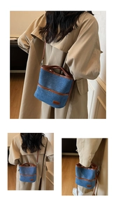 Detail der blauen Denim-Beuteltasche mit braunem Lederbesatz und schicken Kontrastnähten