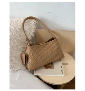 Detail of khaki woven hobo bag with braided handle and matching leather coin purse pouch
