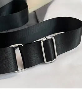 Detail eines verstellbaren schwarzen Nylon-Schultergurts mit silberner Metallschnalle