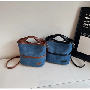 Detail of denim bucket bags with premium leather trim in brown and black finishes
