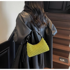 Detail of lime green pearl-embellished underarm bag with quilted diamond pattern