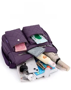 Detail shot showing large capacity of purple nylon crossbody bag with many items