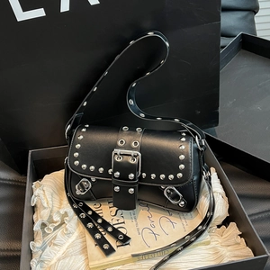 Black punk style leather shoulder bag with silver studs and eyelets in a gift box