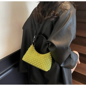 Detail of neon green beaded handbag with black leather trim and pearl texture accents