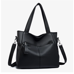 Detailed view of black pebbled leather tote bag featuring fine stitching and dual handles