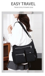 Close-up of black nylon crossbody bag featuring multiple pockets and adjustable strap