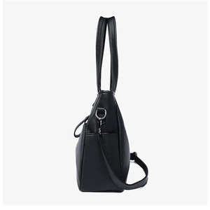 Detail of lychee pattern leather texture and metal D-ring on black tote bag side