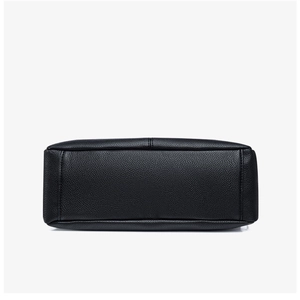 Detailed base view of black lychee grain leather handbag with reinforced stitching