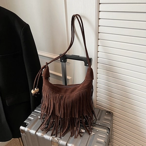 Deep brown suede hobo bag with long fringes and wooden beads on a suitcase handle