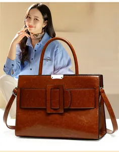 Detail view of brown leather tote bag with large square buckle and vintage texture