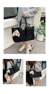 Black textured tote bag with silver metal eyelets and a plush rabbit pendant detail