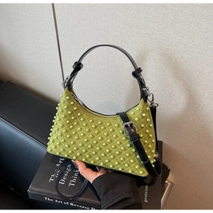 Detail of green suede shoulder bag featuring pearl beading in a quilted diamond pattern