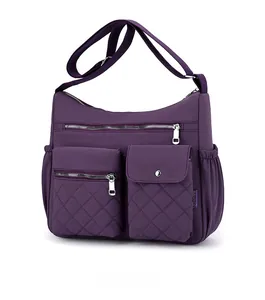Macro side view of purple nylon crossbody bag with multi-zippered pockets and quilting
