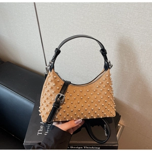 Detail of brown suede hobo bag with quilted stitching and white pearl decorations