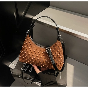 Detail of caramel suede crossbody bag with textured studs and silver hardware buckle