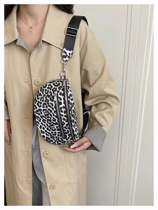 Detail der Crossbody-Brusttasche mit schwarz-weißem Leopardenmuster und Metallreißverschlüssen