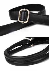 Détail de la boucle dorée ajustable sur la bandoulière noire et poignée de sac confortable