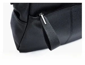 Detail of silver zipper and long leather puller on black pebble grain leather bag