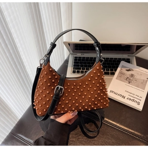 Close-up of brown suede handbag with orange beaded rhombus pattern and black leather strap