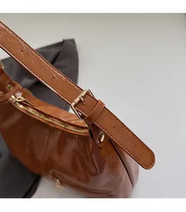 Close-up of premium brown faux leather texture with elegant gold hardware and zipper