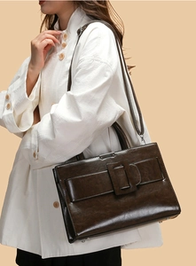 Detail view of deep brown vintage handbag featuring flap closure and leather square buckle