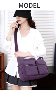 Detailed view of purple quilted nylon crossbody bag featuring multiple zipper pockets