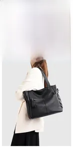 Detail of black pebbled leather tote bag with vertical zipper and minimal stitching