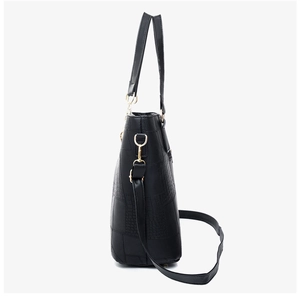 Side view of black faux leather bag featuring crocodile texture and gold hardware details