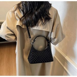 Detail of black punk shoulder bag with pearls on khaki trench coat back view