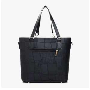 Detail of black tote bag back with textured crocodile skin patchwork and zip pocket