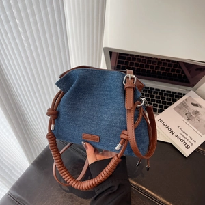 Vintage denim and brown leather bucket bag with spiral handle and adjustable strap