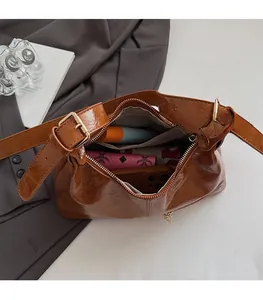 Detail view of brown glossy tote bag interior showing large capacity for essentials