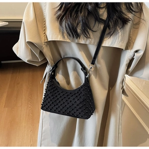 Detail of punk style half-moon shoulder bag featuring black textured pearl beads