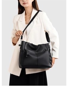 Detail view of black lychee texture leather shoulder bag with silver hardware and pockets