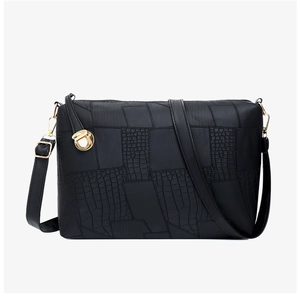 Detail view of black crocodile texture and smooth leather stitching with gold hardware buckle