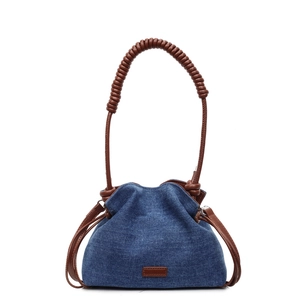 Blue denim bucket bag with brown woven handle and leather details on white background
