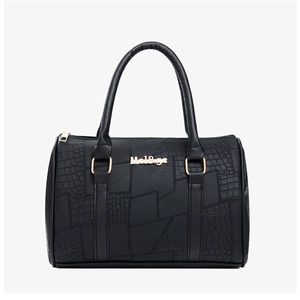 Close-up of black crocodile pattern leather texture and gold hardware on tote bag