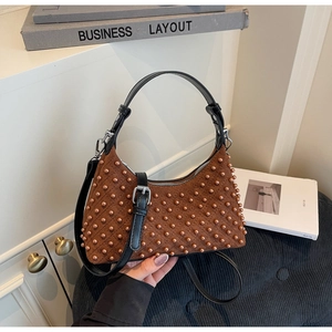 Macro shot of brown suede handbag featuring detailed pearl-like beads and silver hardware
