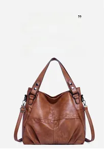 Detail view of brown faux leather tote with pebble texture and adjustable strap