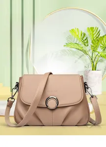 Close-up of khaki pebbled leather shoulder bag featuring a silver metal ring buckle