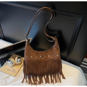 Detailaufnahme der braunen Wildledertasche mit sternförmigen Nieten und langen Fransen