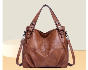 Detail of brown PU leather tote bag featuring metal rivets and detachable shoulder strap