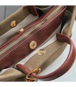 Detail of the tote bag interior featuring brown leather trim and metal zipper pocket