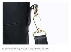 Detail view of glossy golden metal hook and detachable black leather strap connectors