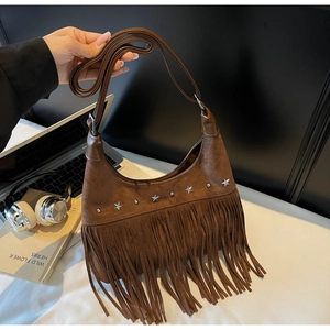 Detail der dunkelbraunen Wildlederimitat-Tasche mit langen Fransen und Sternnieten