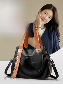 Détail du sac cabas en cuir grainé noir avec plis rayés et ornements FEDN dorés