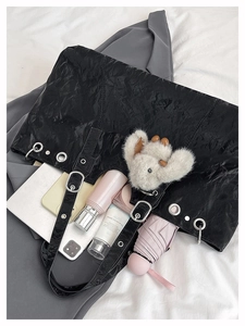 Spacious black tote bag with oil-wax texture showing interior storage capacity and tablet