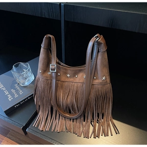 Detail der braunen Wildleder-Hobo-Tasche mit Fransen und silbernen Sternnieten