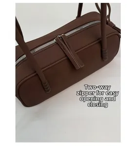 Détail d'un sac Boston marron foncé avec fermeture éclair bidirectionnelle en métal argenté